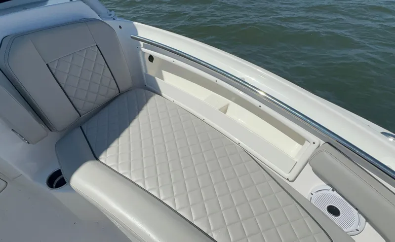 Slide: The Image of 2023 Pursuit DC 246 Dual Console boat interior with cushioned seating and ocean view. - 29