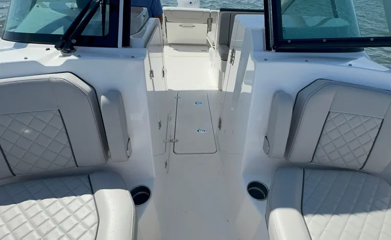 Slide: The Image of 2023 Pursuit DC 246 Dual Console interior with cushioned seating and open deck layout. - 30