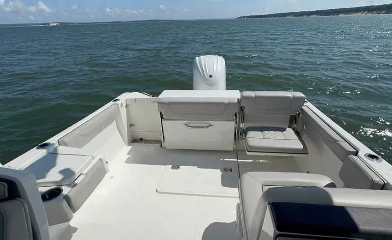 Slide: The Image of 2023 Pursuit DC 246 Dual Console boat on open water, featuring spacious seating. - 9