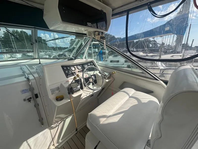 Slide: The Image of 1998 Wellcraft 330 Coastal boat cockpit with steering wheel, gauges, and white seating. - 13