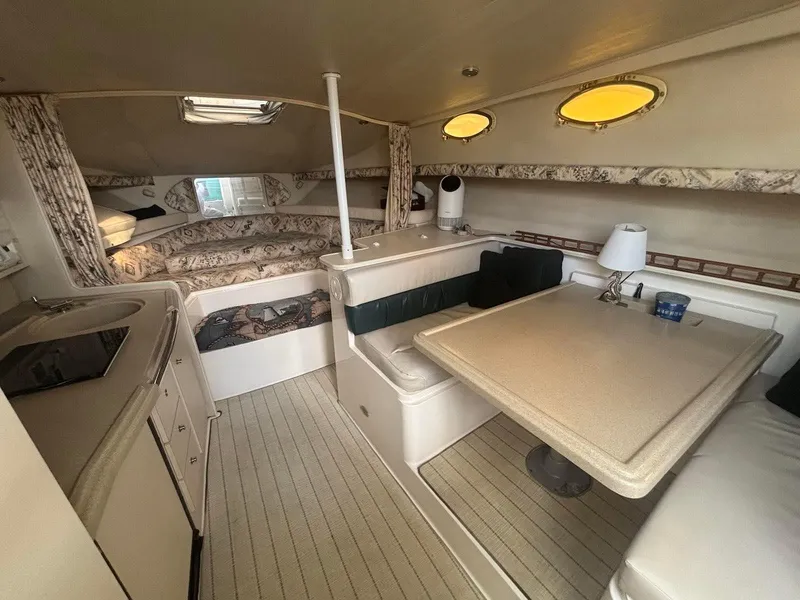 Slide: The Image of 1998 Wellcraft 330 Coastal cabin interior with dining area, kitchenette, and cozy sleeping space. - 16
