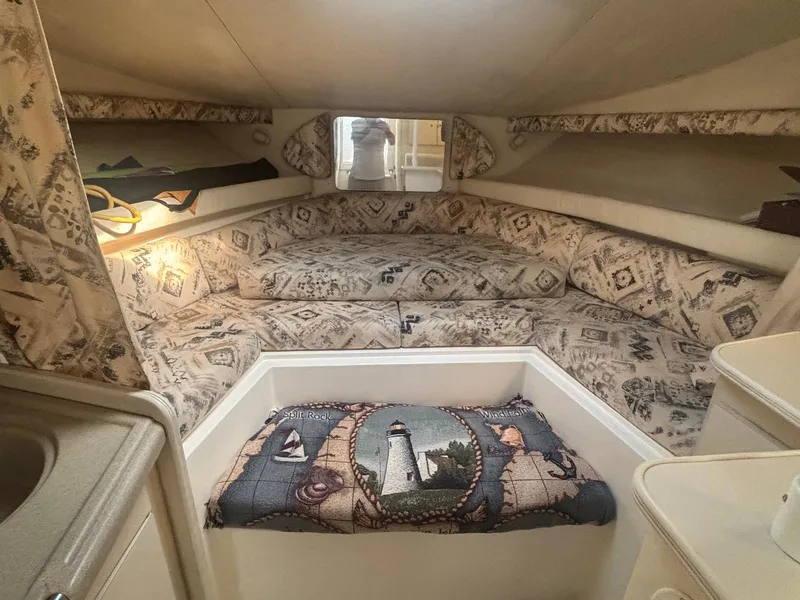 Slide: The Image of 1998 Wellcraft 330 Coastal cabin interior with patterned upholstery and nautical-themed decor. - 17