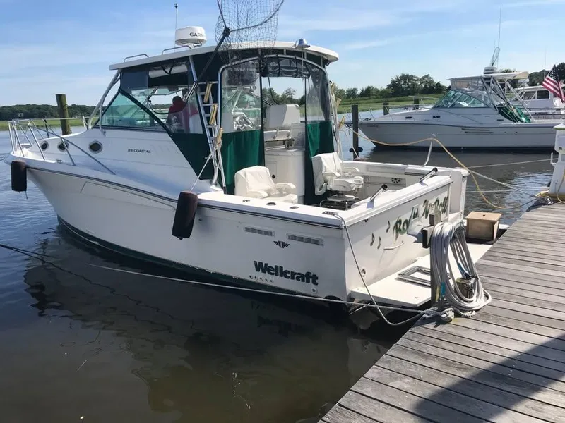 Slide: The Image of 1998 Wellcraft 330 Coastal boat docked at a marina on a sunny day. - 2