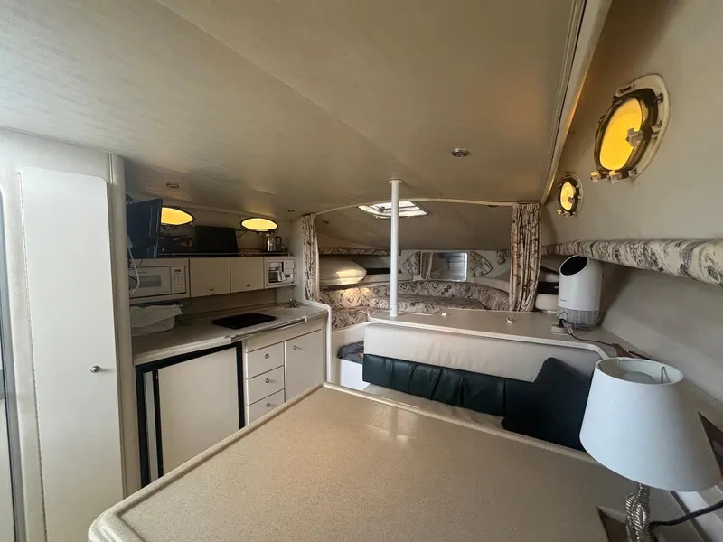 Slide: The Image of Interior of 1998 Wellcraft 330 Coastal boat, featuring kitchen and seating area. - 21