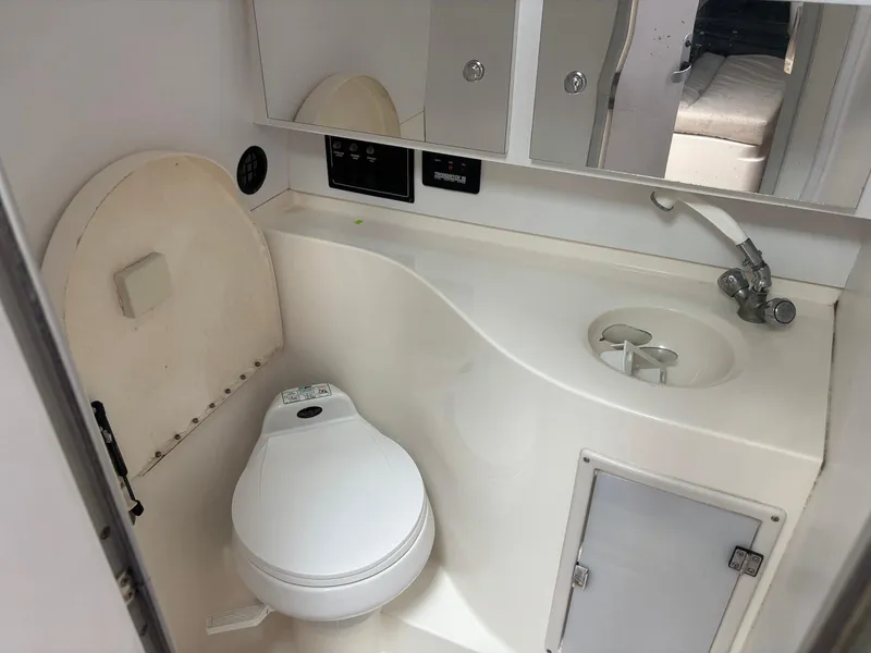 Slide: The Image of 1998 Wellcraft 330 Coastal boat bathroom with toilet, sink, and storage cabinet. - 22
