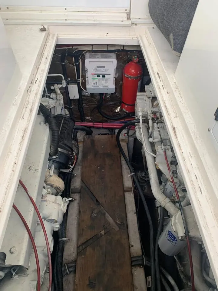 Slide: The Image of Engine compartment of a 1998 Wellcraft 330 Coastal boat, featuring mechanical components and fire extinguisher. - 23