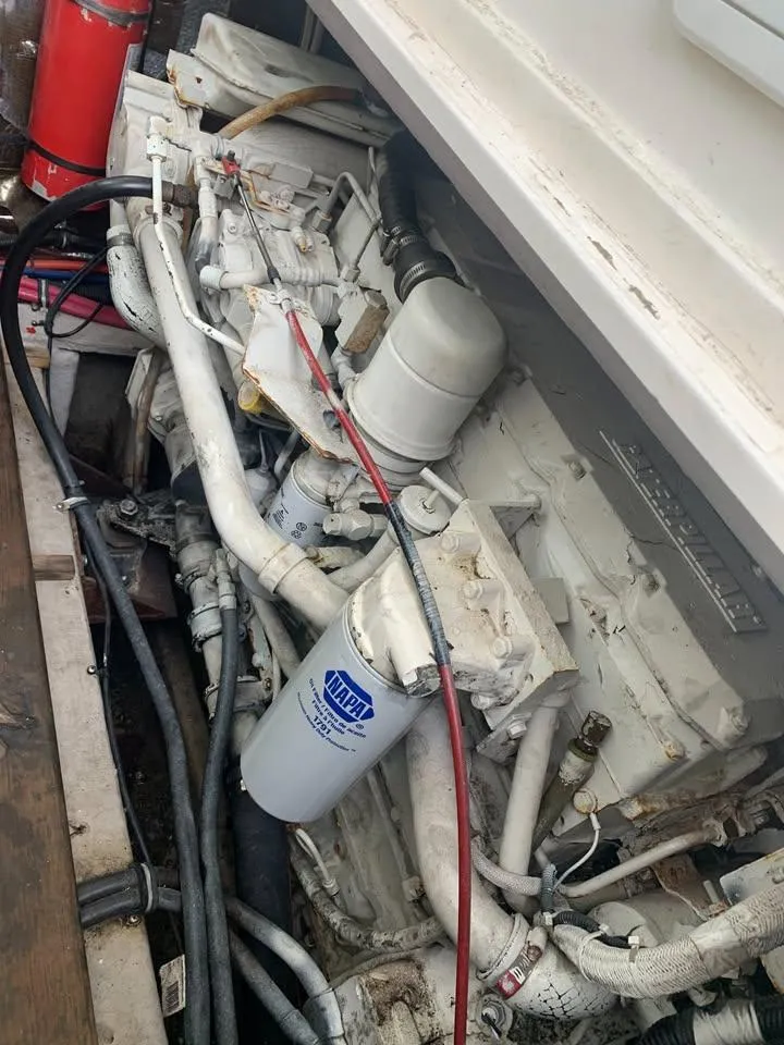 Slide: The Image of Engine compartment of a 1998 Wellcraft 330 Coastal boat, featuring visible hoses and components. - 24