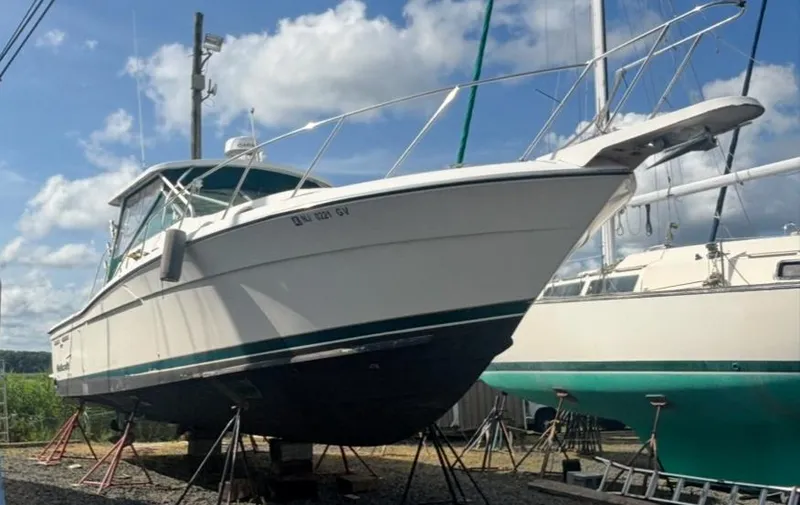 Slide: The Image of 1998 Wellcraft 330 Coastal boat on stands, clear sky background. - 4