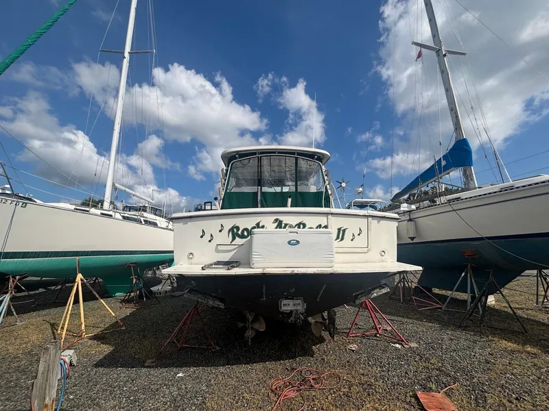 Slide: The Image of 1998 Wellcraft 330 Coastal boat on dry dock, surrounded by sailboats, under a blue sky. - 5