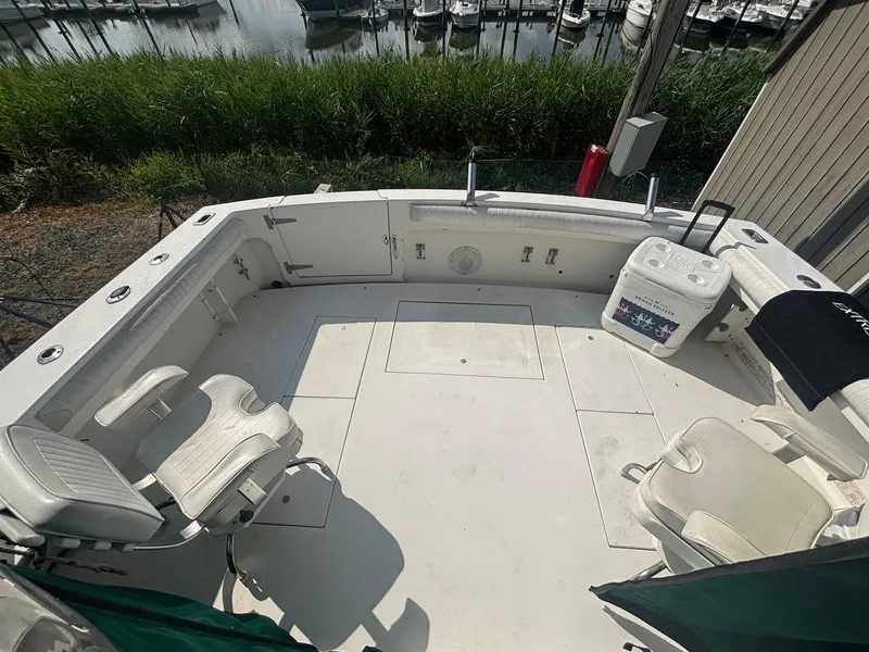 Slide: The Image of 1998 Wellcraft 330 Coastal boat deck with seating, cooler, and marina view. - 7