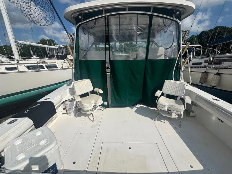Slide: The Image of 1998 Wellcraft 330 Coastal boat deck with chairs and green canopy, docked at marina. - 8