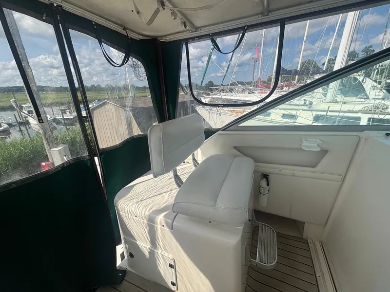 Slide: The Image of Interior view of 1998 Wellcraft 330 Coastal boat with white seating and marina background. - 9