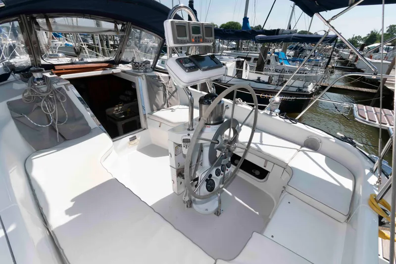 Slide: The Image of 2003 Catalina 310 sailboat cockpit with steering wheel and navigation instruments, docked in marina. - 2