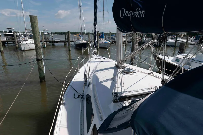Slide: The Image of 2003 Catalina 310 sailboat docked at marina under clear sky. - 7