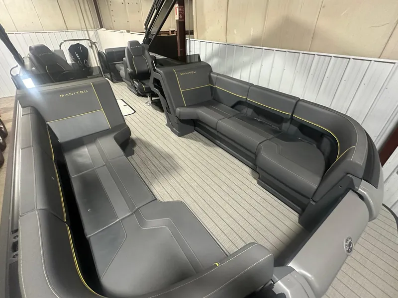 Slide: The Image of 2023 Manitou Explore 24 Navigator with Trifold Bench, featuring sleek gray seating. - 5