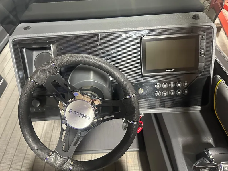 Slide: The Image of 2023 Manitou Explore 24 Navigator dashboard with steering wheel and Garmin display. - 8