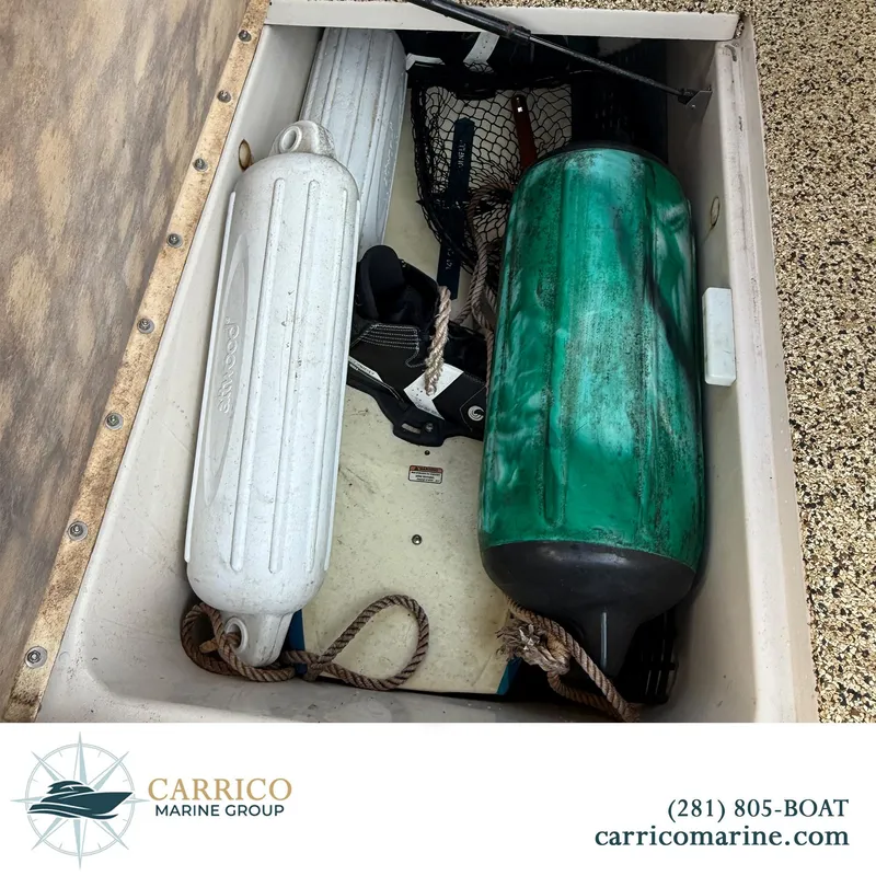 Slide: The Image of Storage compartment with boat fenders and gear on a 2003 Sea Ray 220 Bow Rider. - 21