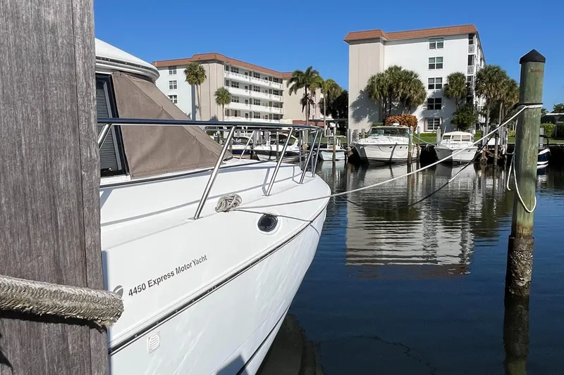 Slide: The Image of 2000 Cruisers Yachts 4450 Motor Yacht docked in a marina with buildings in background. - 10