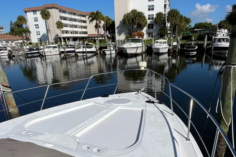 Slide: The Image of 2000 Cruisers Yachts 4450 Motor Yacht docked in a marina with palm trees. - 18