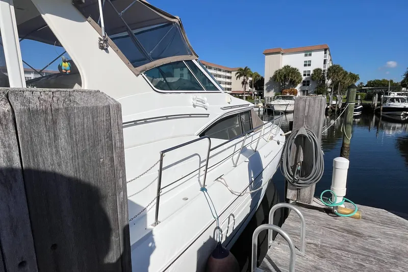 Slide: The Image of 2000 Cruisers Yachts 4450 Motor Yacht docked at marina under clear blue sky. - 3
