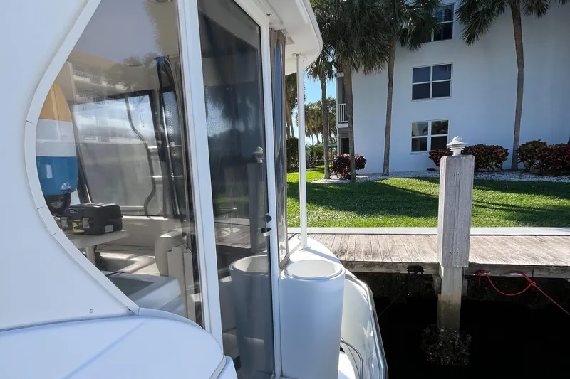 Slide: The Image of 2000 Cruisers Yachts 4450 Motor Yacht docked near a waterfront property. - 39