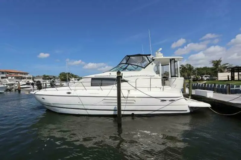 The Image of 2000 Cruisers Yachts 4450 Motor Yacht docked in a marina under clear blue skies. - 0