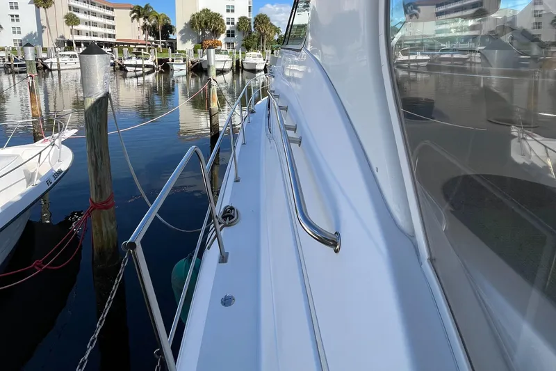 Slide: The Image of 2000 Cruisers Yachts 4450 Motor Yacht docked at marina, side view with railing. - 45