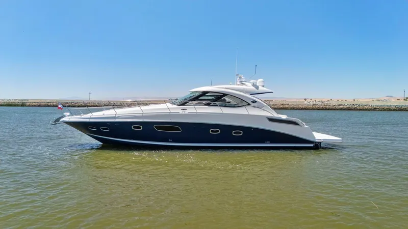 Slide: The Image of 2009 Sea Ray 43 Sundancer yacht on calm water under clear blue sky. - 16