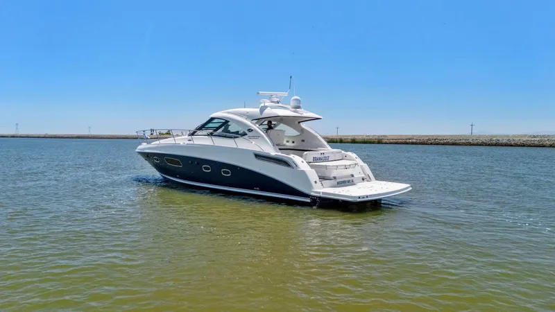 Slide: The Image of 2009 Sea Ray 43 Sundancer yacht cruising on calm waters under clear blue sky. - 17