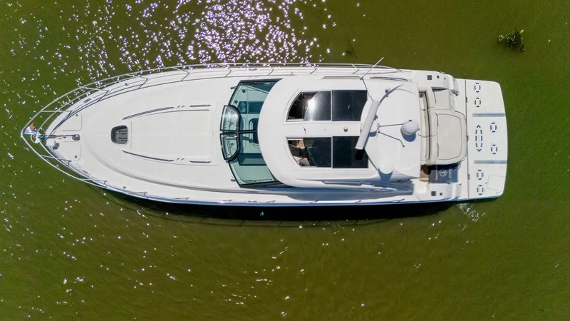 Slide: The Image of Overhead view of a 2009 Sea Ray 43 Sundancer yacht on green water. - 19
