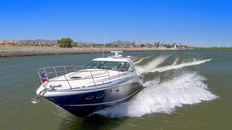Slide: The Image of 2009 Sea Ray 43 Sundancer yacht cruising on a sunny day, creating waves. - 2