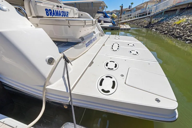 Slide: The Image of 2009 Sea Ray 43 Sundancer docked, featuring spacious swim platform and sleek design. - 20