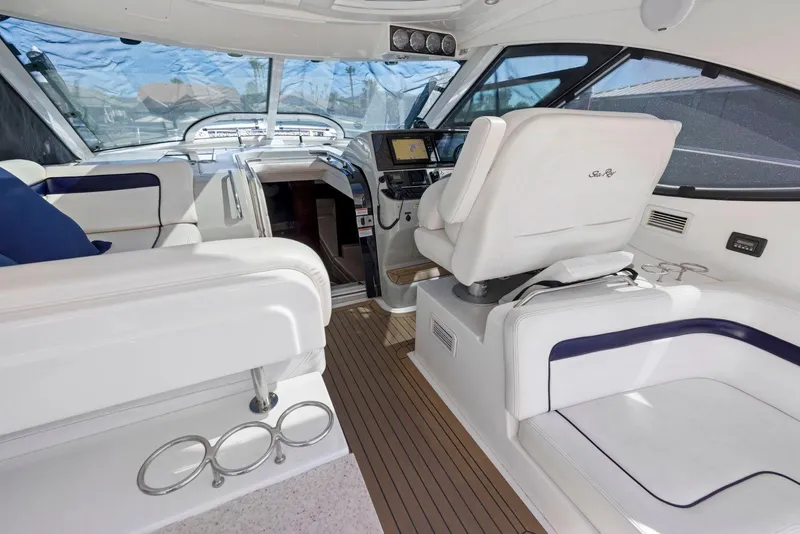 Slide: The Image of 2009 Sea Ray 43 Sundancer yacht interior with white seating and modern dashboard. - 29