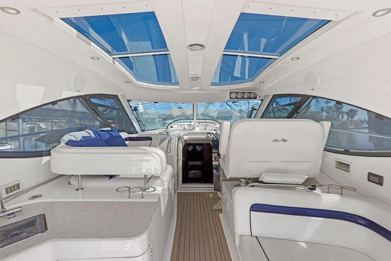 Slide: The Image of 2009 Sea Ray 43 Sundancer yacht interior with white seating and blue accents. - 30