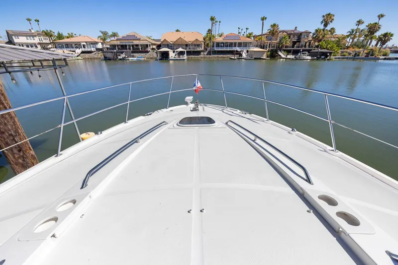 Slide: The Image of Bow view of 2009 Sea Ray 43 Sundancer yacht in a serene waterfront setting. - 41