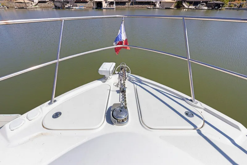 Slide: The Image of Bow of 2009 Sea Ray 43 Sundancer with anchor and flag on calm water. - 42