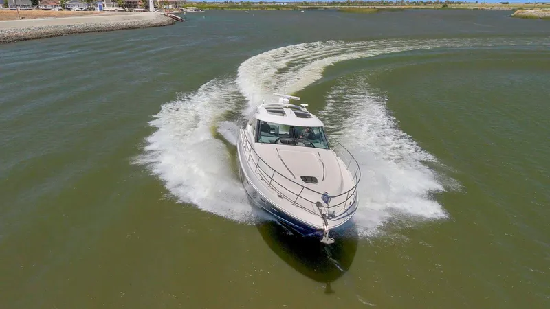 Slide: The Image of 2009 Sea Ray 43 Sundancer cruising on a calm waterway, creating a dynamic wake. - 7