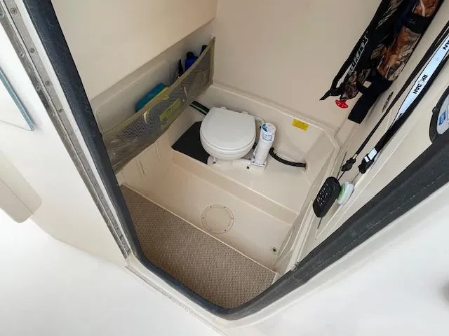 Slide: The Image of 2012 Grady-White 271 Canyon boat interior with compact marine toilet and storage. - 13