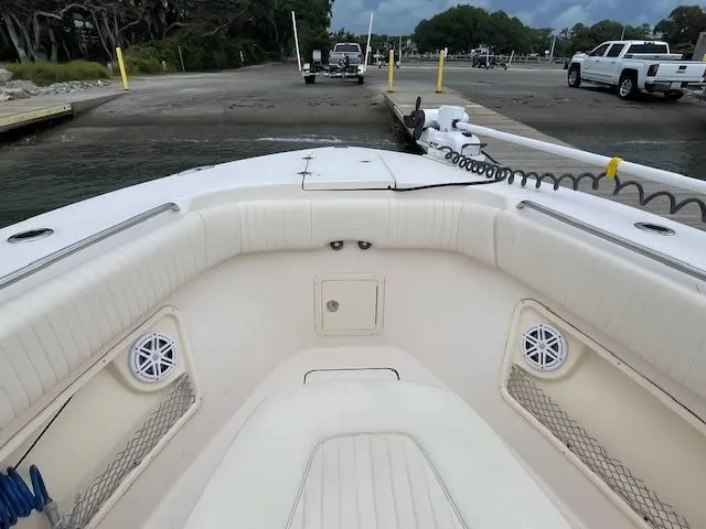 Slide: The Image of 2012 Grady-White 271 Canyon boat interior at dock, featuring spacious seating and speakers. - 15