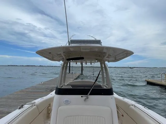 Slide: The Image of 2012 Grady-White 271 Canyon boat docked by the water under a cloudy sky. - 16