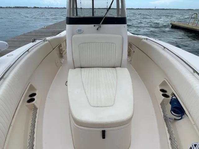 Slide: The Image of 2012 Grady-White 271 Canyon boat interior with cushioned seating, docked by the water. - 21