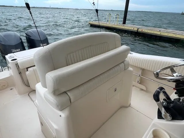 Slide: The Image of 2012 Grady-White 271 Canyon boat interior with dual engines, docked by the water. - 30