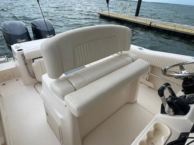 Slide: The Image of 2012 Grady-White 271 Canyon boat interior with dual engines and helm, docked by the water. - 31