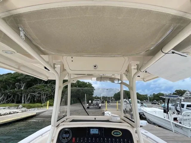 Slide: The Image of 2012 Grady-White 271 Canyon boat at dock, featuring helm and canopy. - 32