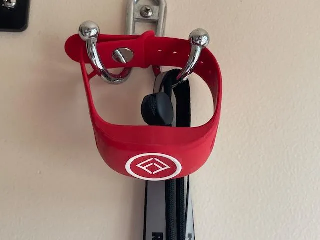 Slide: The Image of Red wall-mounted cup holder with a logo, holding a black strap. - 8