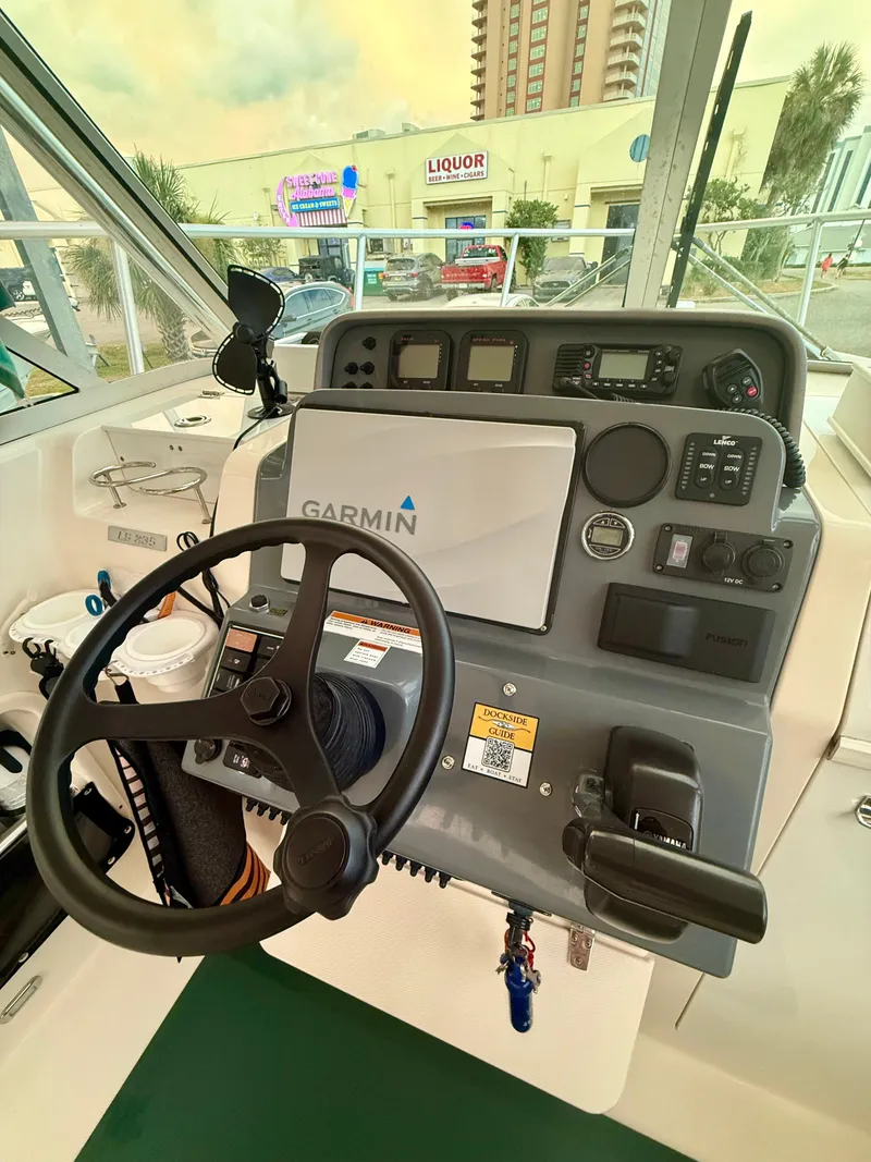 Slide: The Image of 2007 Pursuit 235 Denali LS boat dashboard with Garmin navigation system and steering wheel. - 10