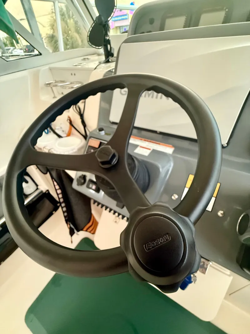 Slide: The Image of Steering wheel of a 2007 Pursuit 235 Denali LS boat, featuring a modern dashboard. - 11