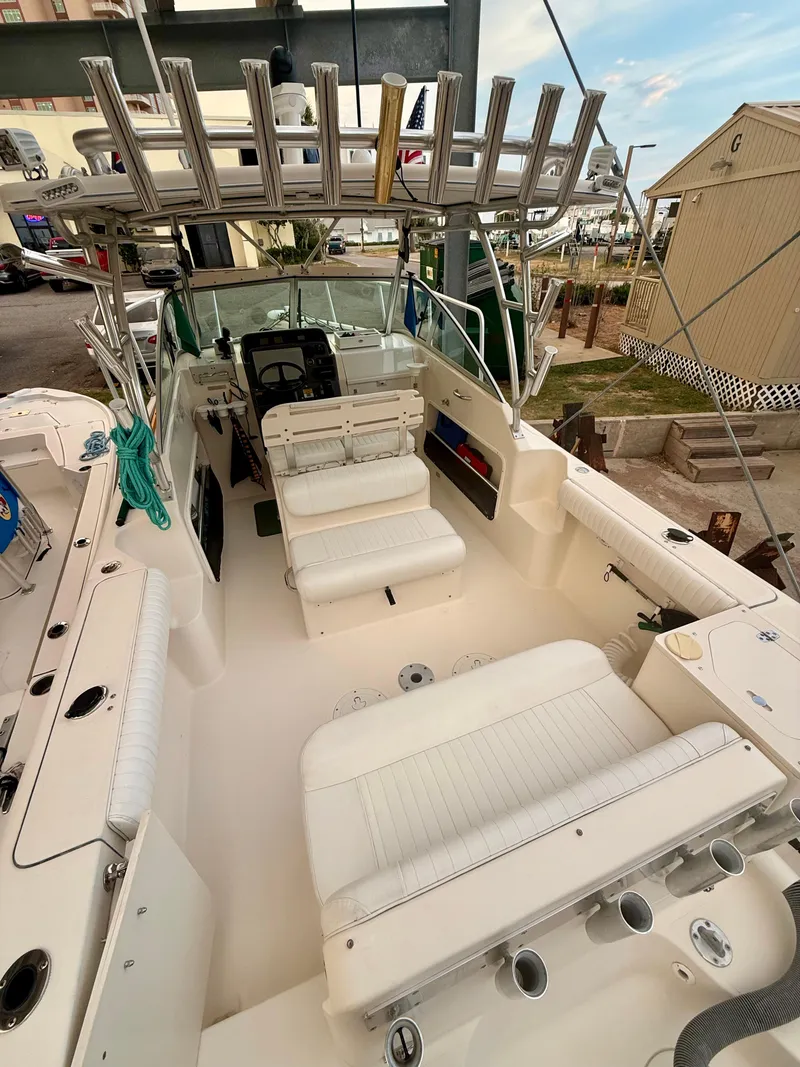 Slide: The Image of 2007 Pursuit 235 Denali LS boat interior with white seating and fishing rod holders. - 12