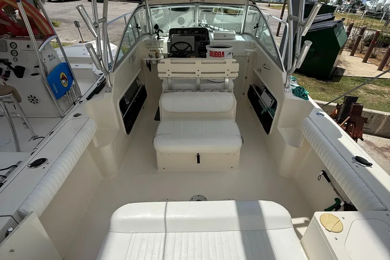 Slide: The Image of 2007 Pursuit 235 Denali LS boat interior with white seating and steering console. - 13