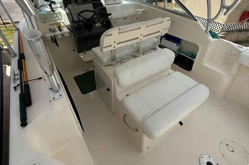 Slide: The Image of 2007 Pursuit 235 Denali LS boat interior with white seating and steering console. - 14